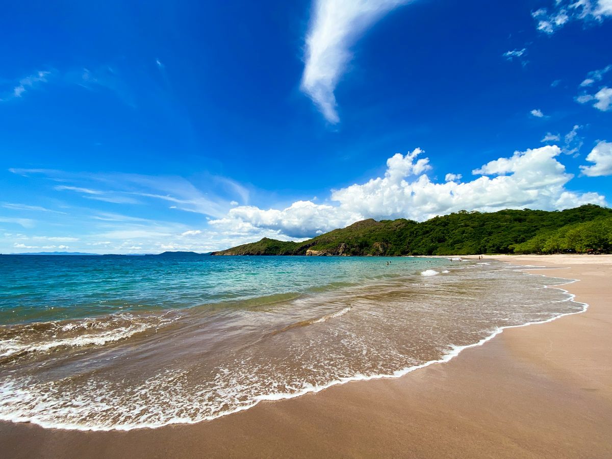 A sandy beach and green headland in Guanacaste